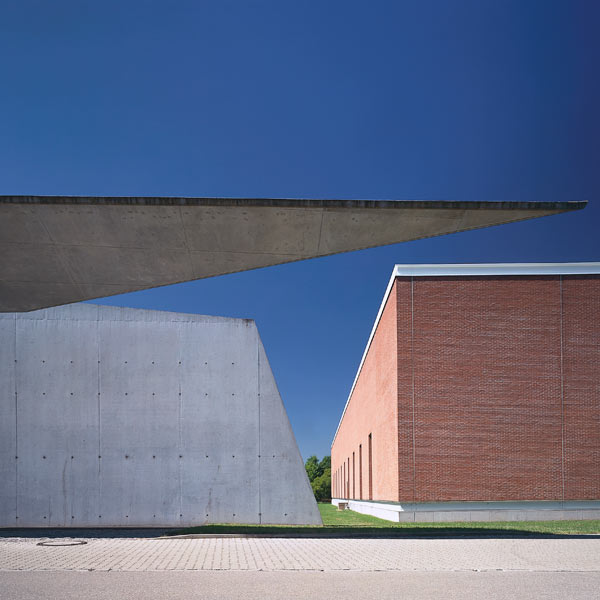 Two fairly ordinary looking buildings with a sharp construction jutting in front of them